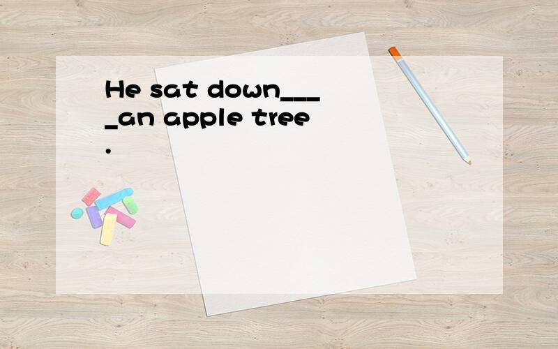 He sat down____an apple tree.